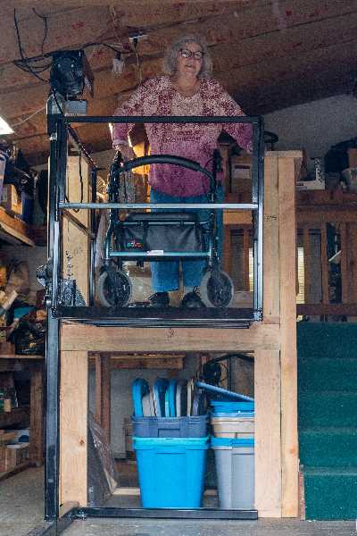 St. Helens resident Patricia McMartin stands on the mobility lift landing in her home garage.